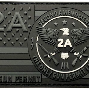 Könnte beinhalten: Ein schwarz-weißes Patch mit einem amerikanischen Flaggenmuster. Das Patch zeigt einen Kreis mit einem Adler, zwei Gewehren und dem Text "Second Amendment 1791 The Only Gun Permit I Need". Der Text "2A" erscheint zweimal auf dem Patch.