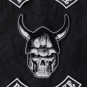 May include: White embroidered patches with the text "Live to Ride" and "Ride to Live" on a black background. A black and white skull wearing a helmet with horns is in the center.