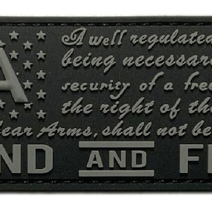 Könnte beinhalten: Ein schwarzer und grauer gestickter Aufnäher mit dem Text "2A" und dem Zitat "A well regulated Militia, being necessary to the security of a free State, the right of the people to keep and bear Arms, shall not be infringed" und dem Text "STAND AND FIGHT".