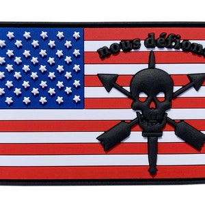 Peut inclure: Un écusson brodé noir et blanc avec un motif de drapeau américain. Le drapeau a 13 bandes rouges et blanches et un champ bleu avec 50 étoiles blanches. L'écusson présente également un crâne et des os croisés avec le texte "nous défions" au-dessus.