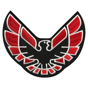 May include: Red and white embroidered patch of a stylized black bird with wings spread wide. The bird is a classic car logo.