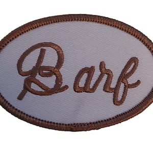 Pode incluir: Etiqueta ovalada bordada em marrom com a palavra "Barf" em fonte cursiva.
