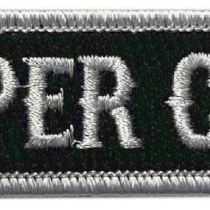 May include: A black and silver embroidered patch with the text "Reaper Crew" in white.