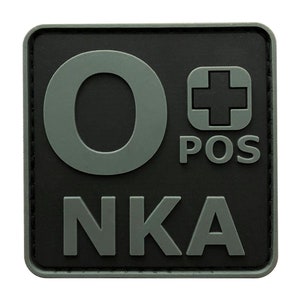 May include: A black and grey square patch with the letters "O POS" and "NKA" in grey. The "O" is large and the "POS" is in a small square with a plus sign inside.