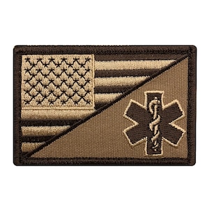 May include: A brown and tan embroidered patch with an American flag on the left side and a medical symbol on the right side.