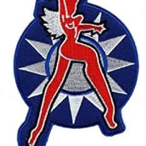 Op de afbeelding: Een geborduurde patch met een gestileerde vrouwelijke figuur in een stervormig ontwerp. De figuur draagt een halo en vleugels. De ster is blauw met witte sterren.