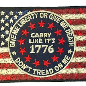 Puede incluir: Un parche bordado con un diseño de bandera estadounidense roja, blanca y azul. El centro del parche presenta un círculo azul con estrellas blancas y el texto "Give Me Liberty or Give Me Death, Carry Like It's 1776, Don't Tread On Me".
