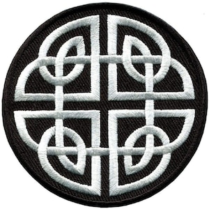 May include: A white Celtic knot design embroidered on a black circular patch. The knot is a traditional symbol of eternity and interconnectedness.