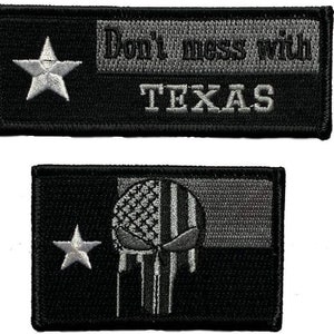 May include: Two black and grey embroidered patches. The first patch features a white star and the text "Don't mess with TEXAS". The second patch features a white star and a grey skull with a black and grey American flag design.