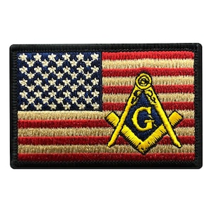 Peut inclure: Un patch brodé représentant le drapeau américain avec un symbole maçonnique jaune dans le coin inférieur droit. Le symbole comprend une boussole et une équerre avec une lettre G au centre.
