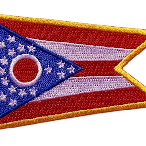 May include: An embroidered patch featuring the Ohio state flag. The flag is a blue triangle with a white circle and 17 white stars, set against a red and white striped background. The patch is outlined in gold.
