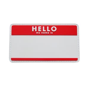 May include: White name tag with a red top bar that says "HELLO my name is".