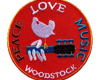 May include: A red, round embroidered patch with the words "Peace, Love, Music, Woodstock" around the edge. A white dove with a blue guitar is in the center.