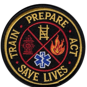 May include: A circular embroidered patch with a black background and gold border. The text "TRAIN PREPARE ACT SAVE LIVES" is stitched in gold. The centre features a red cross dividing four icons: a tan ladder, a red fire hydrant, a flame, and a blue star of life.