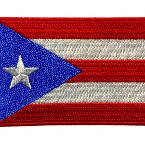 May include: Embroidered patch of the Puerto Rican flag. The flag is red, white and blue with a white five-pointed star on a blue triangle.