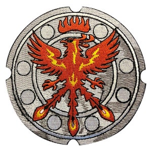 May include: A circular embroidered patch with a silver background and a red phoenix with yellow accents. The phoenix is surrounded by a silver ring with five circles.