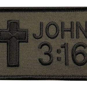 May include: A black embroidered patch with a green background. The patch features a cross and the text "JOHN 3:16".
