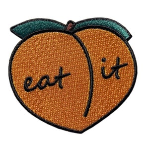 May include: A peach-shaped embroidered patch with the text "eat it" in black lettering.