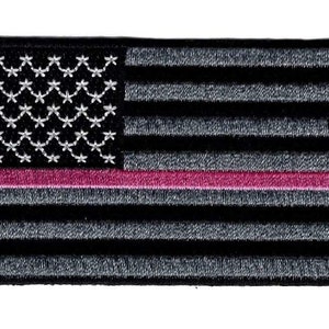 Könnte beinhalten: Schwarzer und grauer amerikanischer Flaggen-Patch mit einem dünnen rosa Streifen in der Mitte. Die Sterne sind weiß.