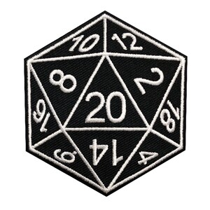 May include: Black and white embroidered patch of a twenty-sided die, also known as a d20. The die has numbers 1, 2, 4, 6, 8, 10, 12, 14, 16, 18, and 20 on its faces.