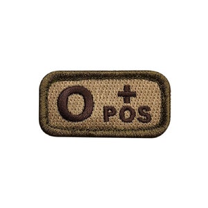 May include: A brown and tan rectangular patch with the text "O+ POS" embroidered in brown thread.