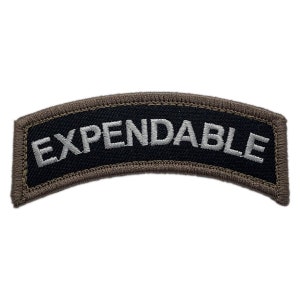 Puede incluir: Un parche de tela negro y marrón con texto bordado en blanco que dice "EXPENDABLE".