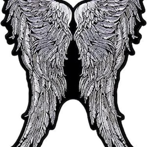 Puede incluir: Un gran parche bordado en plata de alas de ángel con diseños detallados de plumas. Las alas están sobre un fondo negro.