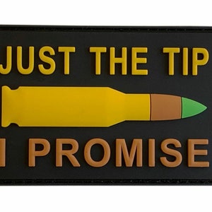 May include: Black patch with yellow text that reads "JUST THE TIP I PROMISE". A yellow bullet with a brown tip and a green end is centered below the text.