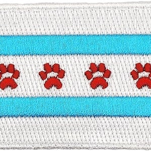 May include: A white patch with two blue stripes and four red paw prints. The patch is a representation of the Chicago flag.