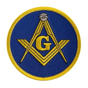 以下が含まれることがあります： コンパスと直角定規、中央に「G」、上部に小さな円が描かれた青と金の刺繍パッチです。