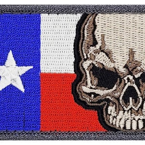 May include: Embroidered patch featuring a skull with a Texas flag design. The skull is beige and brown with black eyes. The flag is blue, white, and red with a white star in the blue section.