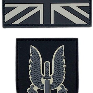 May include: Two black and white embroidered patches. The first patch is a Union Jack flag. The second patch is a black shield with a white winged dagger and the text "Who Dares Wins".