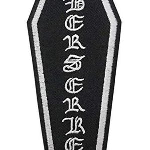 May include: Black coffin-shaped patch with white embroidered text that reads "BEREAVER". The patch has a white border. The design is gothic and suitable for jackets, bags, or other apparel.