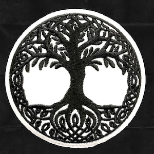 以下が含まれることがあります： 生命の木のデザインが刺繍された黒と白のパッチ。木は複雑な結び目の輪で囲まれています。