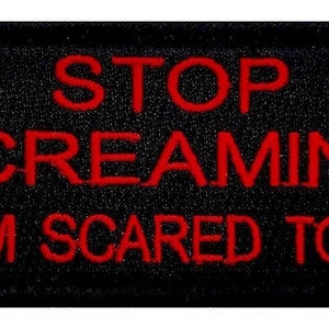 May include: Black embroidered patch with red text that reads "STOP SCREAMING "I'M SCARED TOO"