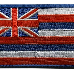May include: An embroidered patch featuring the flag of Hawaii. The flag is a blue field with eight horizontal stripes of red and white, and a Union Jack in the upper left corner.
