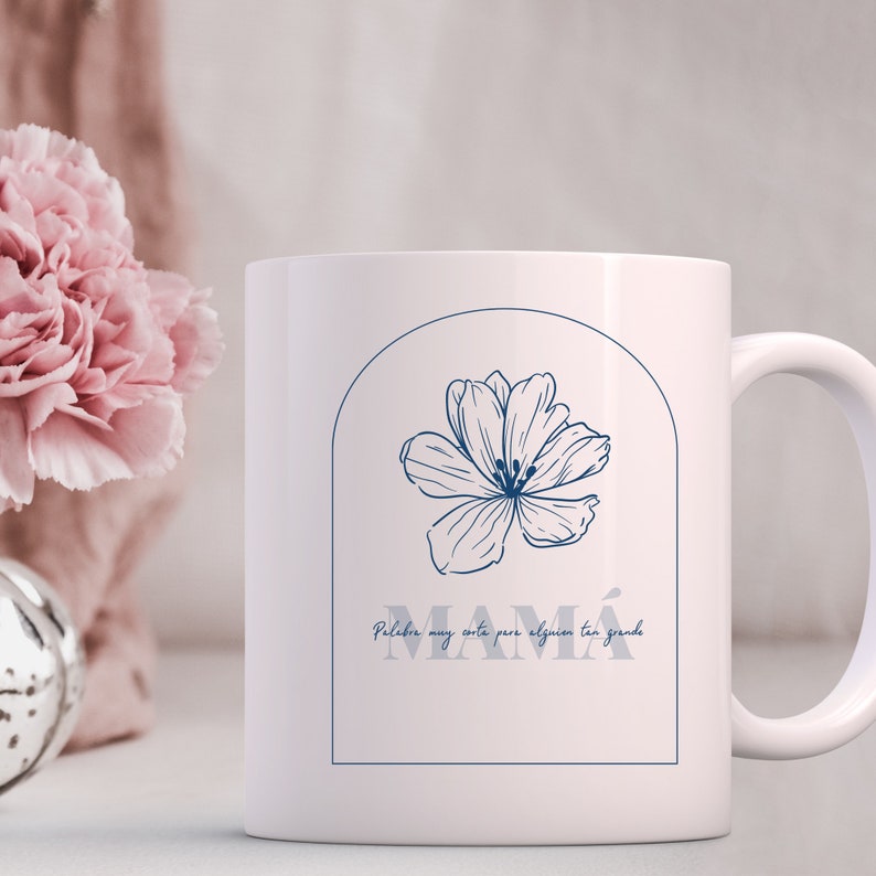 Pode incluir: Caneca de cer&acirc;mica branca com um design floral azul e o texto "Palabra muy corta para alguien tan grande MAMA" em um arco azul.