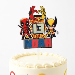 May include: A cake topper featuring Deadpool, Wolverine, and the number 13, with the name "Noah" below. The figures are set against a colorful background, with a clear plastic stick for insertion into a cake.