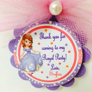 May include: Purple and pink favor tag with a cartoon image of Princess Sofia the First. The tag says "Thank you for coming to my Royal Party! Love, Sofia".