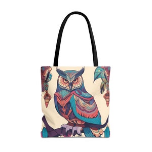 Puede incluir: Una bolsa de tela beige con un diseño de búho colorido. El búho es azul, morado, rojo y naranja con patrones intrincados. La bolsa tiene asas negras.