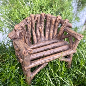 Peut inclure: Un banc miniature en bois fait de petites bûches, parfait pour un jardin de fées ou une scène miniature. Le banc est brun et a un aspect rustique.