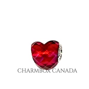 May include: A red heart-shaped charm with a faceted design. The charm is made of glass and has a silver-toned metal attachment.