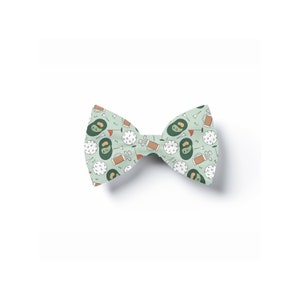 May include: A green bow tie with a golf-themed pattern. The pattern includes golf balls, golf clubs, golf bags, and golf flags.