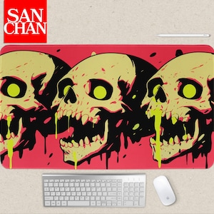 May include: A rectangular mousepad featuring three stylized skulls with yellow and black details, set against a red background. The skulls have green eyes and dripping green liquid. The mousepad has the text "SAN CHAN" in a red square.