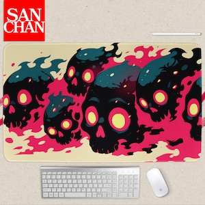 May include: A rectangular mousepad with a design of black skulls with teal flames and yellow eyes, set against a pink and beige background. The mousepad has the text "SAN CHAN" in a red square.
