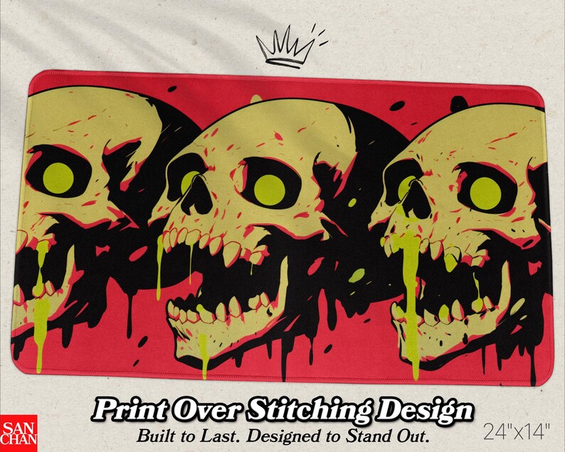May include: A rectangular mat featuring three stylized skulls with yellow and black details against a red background. The skulls have green eyes and dripping yellow accents. The mat measures 24" x 14".