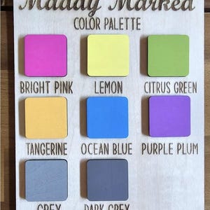 May include: Wooden color palette with the text "Maddy Marked COLOR PALETTE." The palette features nine color swatches in bright pink, lemon, citrus green, tangerine, ocean blue, purple plum, grey, and dark grey.