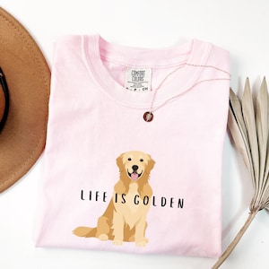 May include: Pink t-shirt with a golden retriever illustration and the text "Life is Golden".
