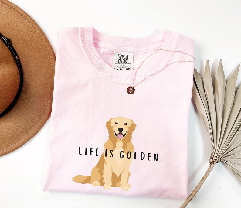 May include: Pink t-shirt with a golden retriever illustration and the text "Life is Golden".