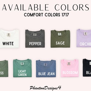May include: A selection of folded t-shirts in various colors, including white, pepper, sage, orchid, moss, light green, blue jean, blossom, and black. The text "AVAILABLE COLORS" and "COMFORT COLORS 1717" is displayed above the shirts.